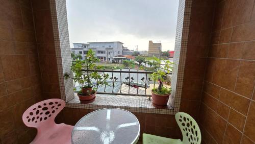 a balcony with a glass table and a window with a view at ChaoPingJia Homestay in Luodong