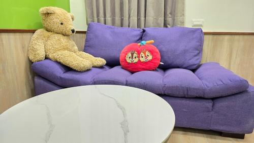 a stuffed teddy bear sitting on a purple couch at ChaoPingJia Homestay in Luodong