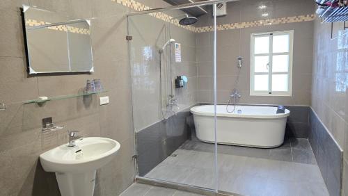 a bathroom with a tub and a sink and a toilet at ChaoPingJia Homestay in Luodong
