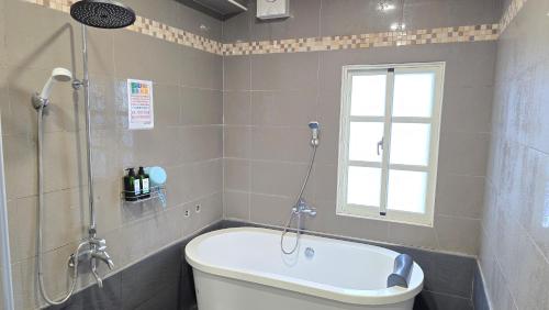 a bathroom with a tub and a shower and a toilet at ChaoPingJia Homestay in Luodong