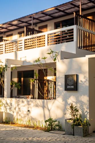 フルハッドホーにあるZen Inn Fulhadhooの側面に看板がある白い建物