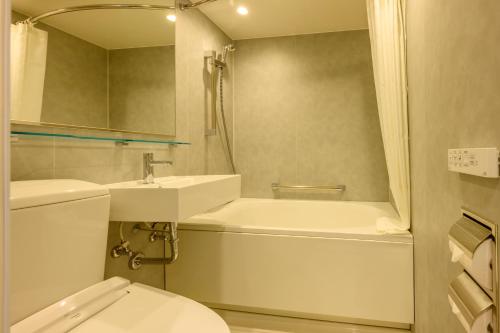 a bathroom with a sink and a toilet and a shower at ART HOTEL Nippori Lungwood in Tokyo