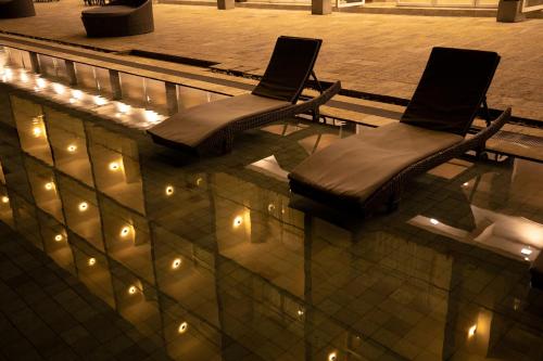 two chairs sitting in a pool with lights in it at The Habitat Kosgoda by Asia Leisure in Bentota