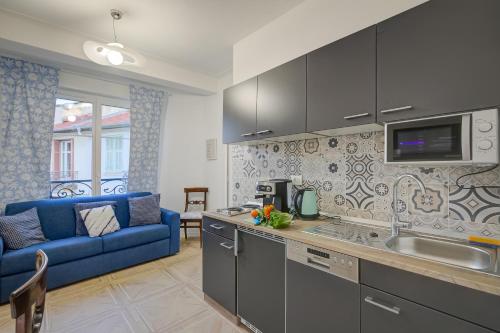 Il comprend une cuisine et un salon avec un canapé bleu. dans l'établissement Paganini City Center - Happy Rentals, à Nice