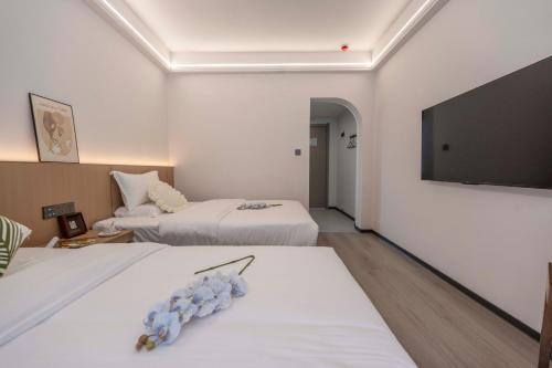 a hotel room with two beds and a flat screen tv at Lane Wisdom Garden Hotel - Lijiang Ancient City Zhongyi Market in Lijiang