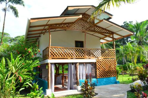 a small house with a roof over a patio at Passion Fruit Lodge in Cahuita
