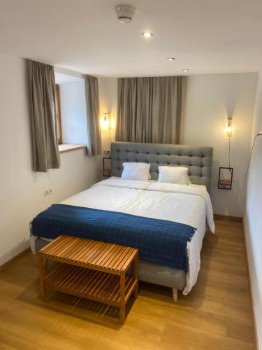 a bedroom with a large bed with a blue blanket at Ferienwohnung Bergblick Flirsch in Flirsch