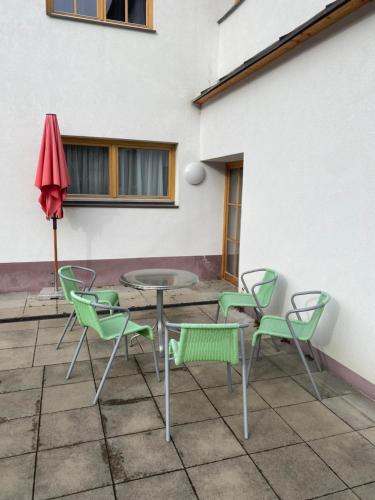 a patio with a table and chairs and an umbrella at Ferienwohnung Bergblick Flirsch in Flirsch