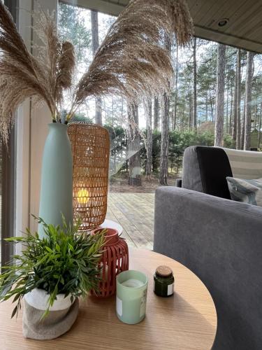 a living room with a table with a vase and plants at L Orée de la Pinède Hardelot Plage à 800 metres de la mer sous les pins in Hardelot-Plage