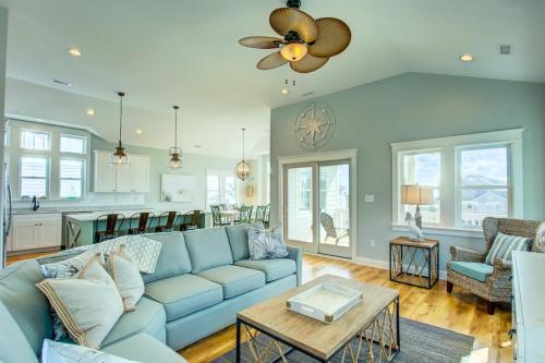 Una sala de estar con un sofá azul y una cocina. en 4056 - Tight Lines Tan Lines, en Playa de Kitty Hawk