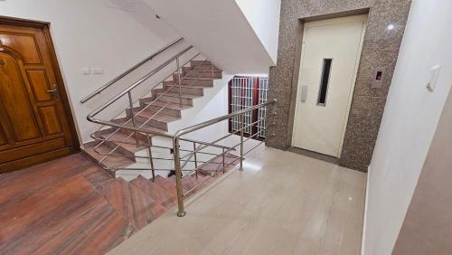 a staircase in a building with a wooden door at Chippy Apartments No 56 in Chennai
