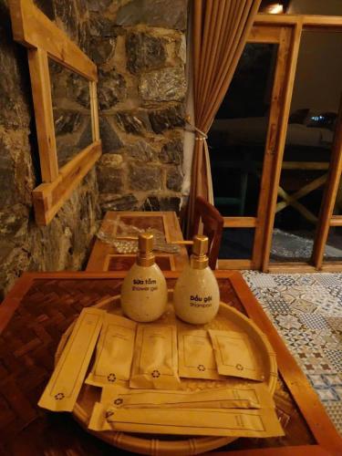 two bottles of soap sitting on top of a wooden table at Ha Giang Ecolodge in Ha Giang