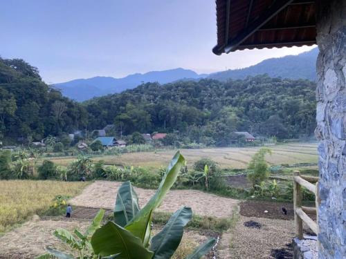 a view of a field and mountains from a house at Ha Giang Ecolodge in Ha Giang