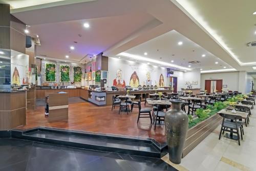 a restaurant with tables and chairs in the middle at Tjokro Hotel Klaten in Klaten