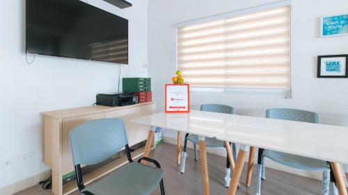 a dining room with a white table and chairs at RedDoorz Plus at Alpina Heights Paranaque in Manila
