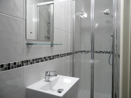 a white sink sitting under a mirror in a bathroom at Medehamstede Hotel in Shanklin