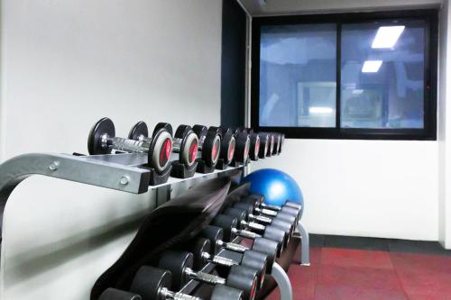 a rack of dumbbells in a room with a window at Annex Lumpini Bangkok in Bangkok