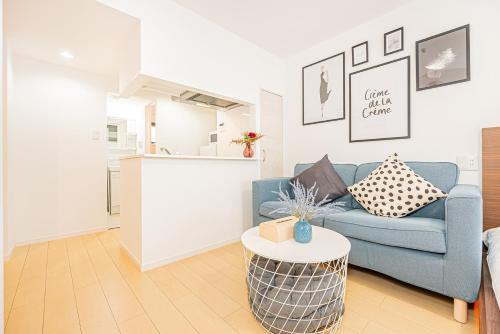 a living room with a blue couch and a table at New-built APT at Asakusa-Skytree area with Tranquil block in Tokyo