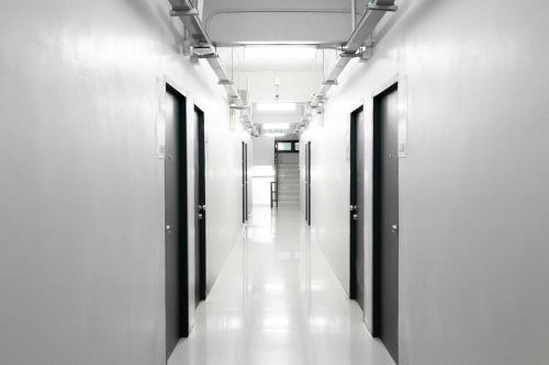 a hallway in a building with white walls and windows at Annex Lumpini Bangkok in Bangkok
