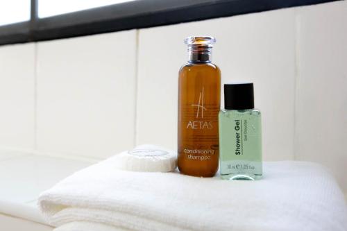 a bottle of essential oil and a bottle of soap on a towel at Annex Lumpini Bangkok in Bangkok