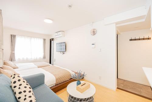 a bedroom with a bed and a blue couch at New-built APT at Asakusa-Skytree area with Tranquil block in Tokyo