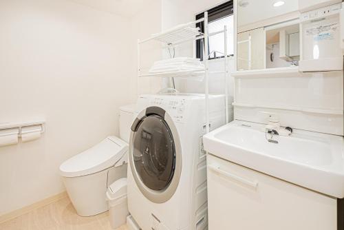 a white laundry room with a washing machine and a sink at New-built APT at Asakusa-Skytree area with Tranquil block in Tokyo