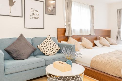 a living room with a blue couch and a bed at New-built APT at Asakusa-Skytree area with Tranquil block in Tokyo