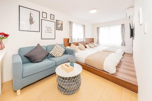 a living room with a bed and a blue couch at New-built APT at Asakusa-Skytree area with Tranquil block in Tokyo