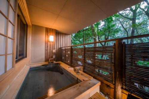 a hot tub on the balcony of a house at Ikyu in Ise