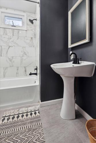 a bathroom with a white sink and a bath tub at Cozy Beach Cottage Near The Bay in Villas