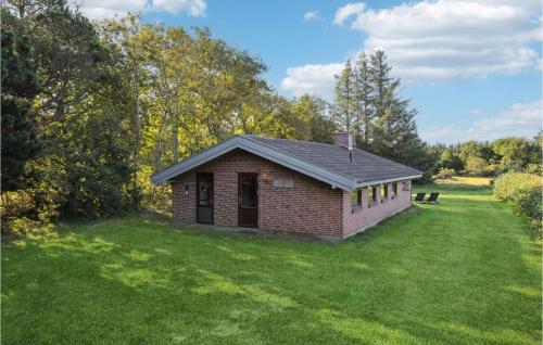 a small brick building on a grass field at Holiday Home Gl Strandvej Henne X in Henne Strand