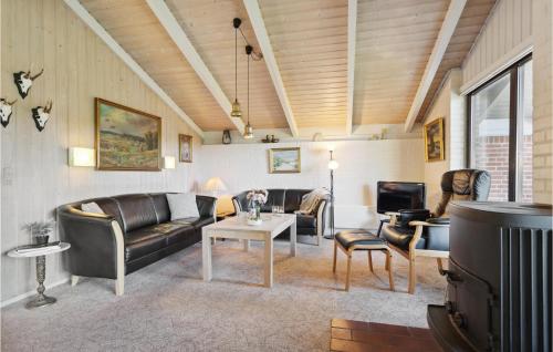 a living room with leather furniture and a tv at Holiday Home Gl Strandvej Henne X in Henne Strand