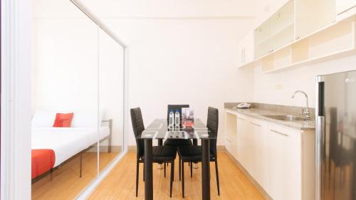 a small kitchen with a table and chairs in a room at RedDoorz Plus at Alpina Heights Paranaque in Manila