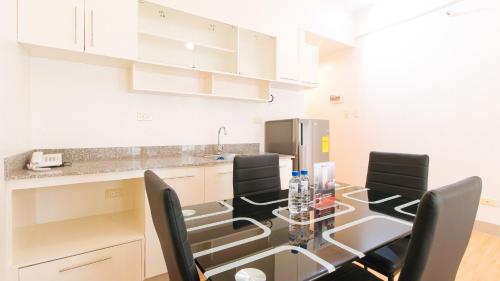 a kitchen with a dining room table and chairs at RedDoorz Plus at Alpina Heights Paranaque in Manila