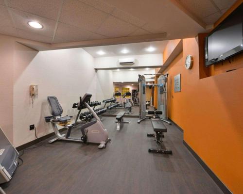 a gym with several tread machines and a flat screen tv at Comfort Suites Chincoteague Island Bayfront Resort in Chincoteague