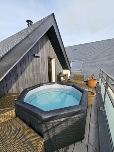 un bain à remous installé sur la terrasse d'une maison dans l'établissement Superbe villa Ty Tabarly, jacuzzi, salle de cinéma, à Crach