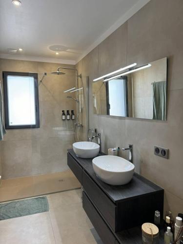 une salle de bain avec deux lavabos et une douche dans l'établissement Superbe villa Ty Tabarly, jacuzzi, salle de cinéma, à Crach