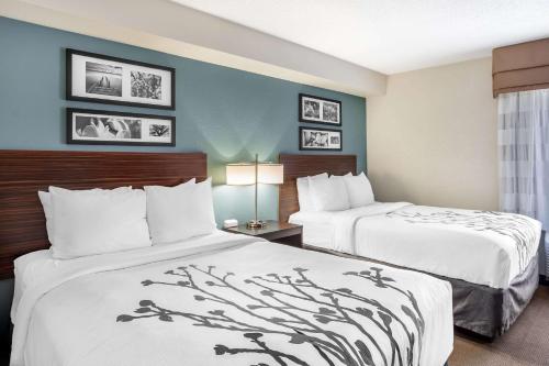 a hotel room with two beds and a window at Sleep Inn near Penn State - State College, PA in State College