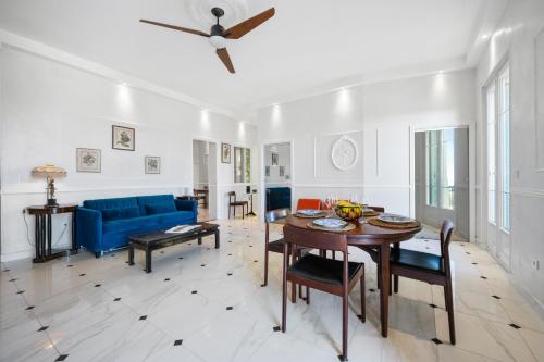 un salon avec un canapé bleu et une table dans l'établissement Alexandra Palace, Appartement Belle Époque Menton, vue mer, parking, à Menton