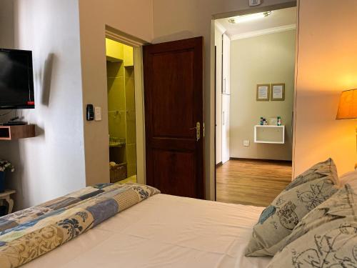 a bedroom with a bed with a television and a hallway at Telestai Guest House in White River