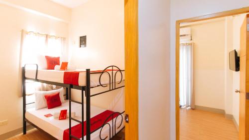 a room with two bunk beds and a mirror at RedDoorz Plus at Alpina Heights Paranaque in Manila