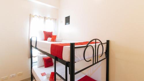 a bedroom with two bunk beds with red pillows at RedDoorz Plus at Alpina Heights Paranaque in Manila