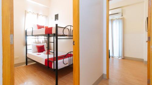 a room with two bunk beds and a mirror at RedDoorz Plus at Alpina Heights Paranaque in Manila