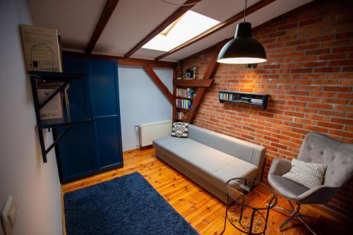 a living room with a couch and a brick wall at Kamienica na Starym Rynku - 140 m2 i garaż in Puck