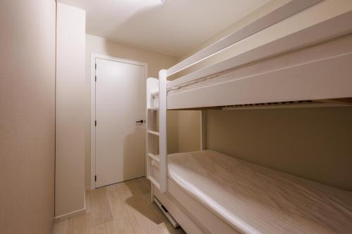 a bedroom with two bunk beds and a door at The CORNR Hotel in Nieuwpoort
