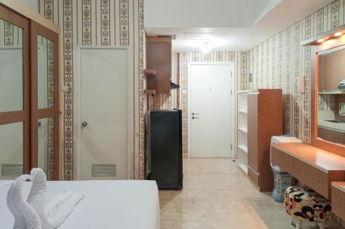 a room with a refrigerator and a room with a hallway at Minimalist and Comfort Studio Podomoro City Deli Medan Apartment By Travelio in Medan