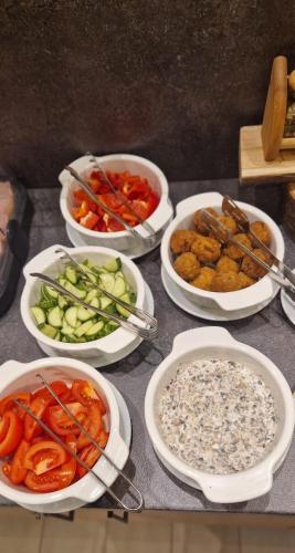 a table topped with bowls of different types of food at Casa Calfelor Kolping Timișoara in Timişoara