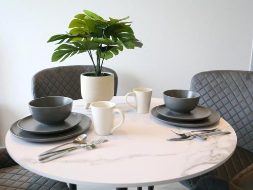 a table with two cups and a potted plant on it at Regent Road - 9th Floor, Pets Allowed, 24hr Shop - Pass the Keys in Manchester