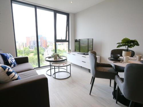 a living room with a couch and a table and a tv at Regent Road - 9th Floor, Pets Allowed, 24hr Shop - Pass the Keys in Manchester