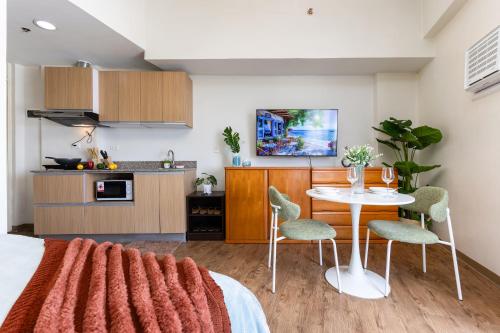 a room with a bed and a table and chairs at 617A Condotel Near Airport &Mall with Pool,Gym,Netflix in Mactan Cebu International